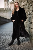 Black fur coat with button-front, long sleeves, mid-calf length, walking view.