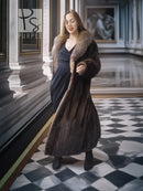 Full-length mink coat with dark fur trim, long sleeves, belted wrap silhouette