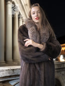 Mink fur coat with fox-trim collar; arms crossed showing plush sleeve texture