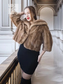 Tan mink fur opera jacket with hood, angled front view with raised collar