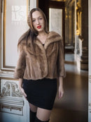 Vintage mink opera jacket with hood, tan fur texture, three-quarter view front.