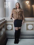 Vintage mink opera jacket with hood, tan fur, cropped fit over a black mini dress.