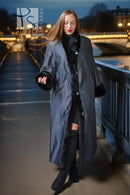 Full-length black mink fur coat with high collar and button front, styled with gloves.