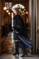 Long black mink fur coat, open front and flowing drape with wide collar.