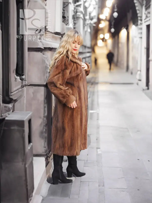 Brown mink fur coat with hood and straight front, mid-calf length.