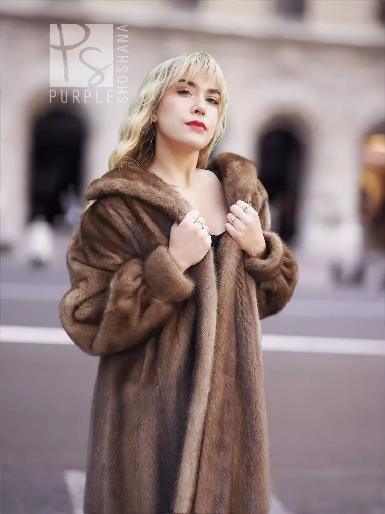 Women’s brown mink fur coat with hood, front close-up holding collar