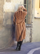 Back view of a brown mink fur coat with hood and long sleeves.