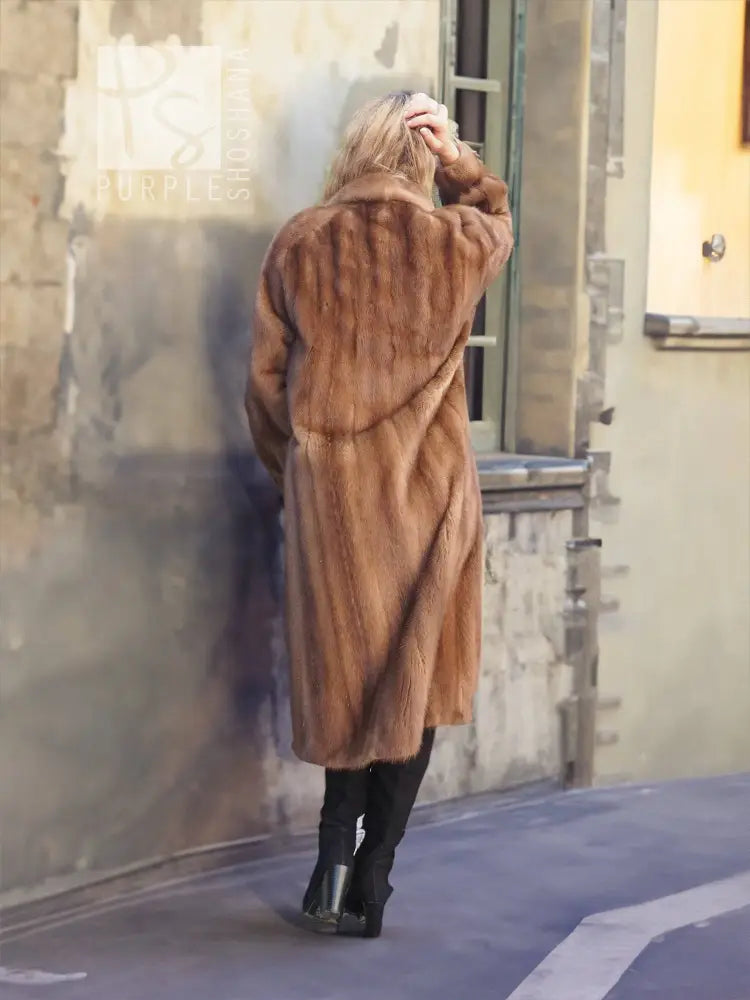Back view of a brown mink fur coat with hood and long sleeves.