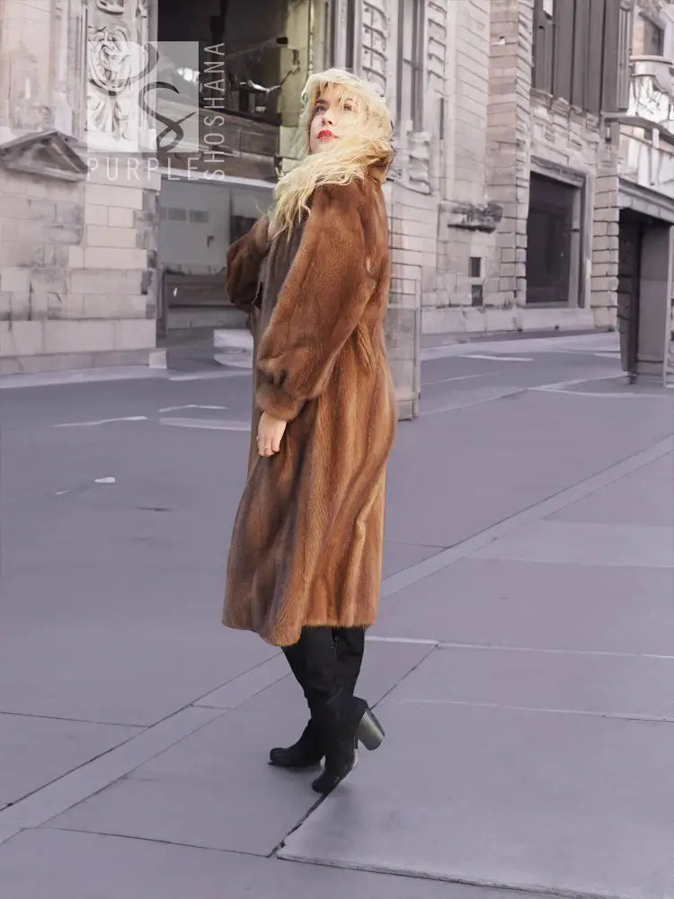 Women's brown mink fur coat, side view with plush collar and long hem.