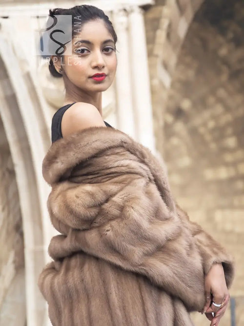 Light brown mink fur coat with oversized fur collar and hood, side close-up.