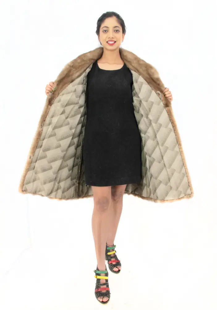 Light brown mink fur coat with quilted inner lining, open front and flared hem
