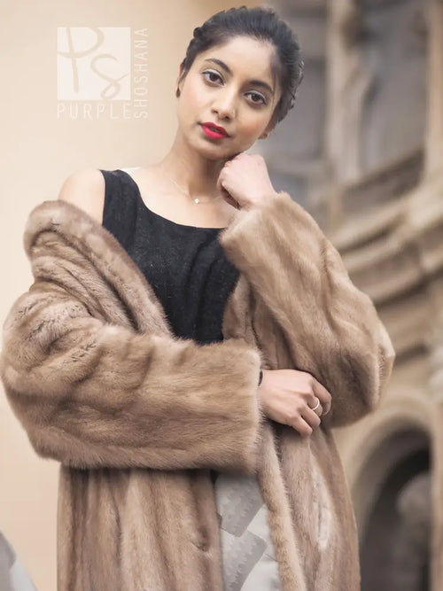 Light brown mink fur coat with wide fur cuffs and wrap-style front, side view