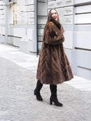 Swing mink fur coat in dark brown with V-shaped collar, long hem, directional weave
