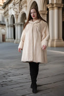Cream mink coat with wide swing silhouette and plush collar; long sleeves