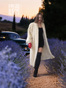 Cream fur coat draped over a black outfit with open front and wide sleeves
