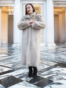 Light gray herringbone mink coat, front view with clasped hands near button placket
