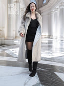 Light gray long mink-style coat with hooded plush collar and chevron texture.