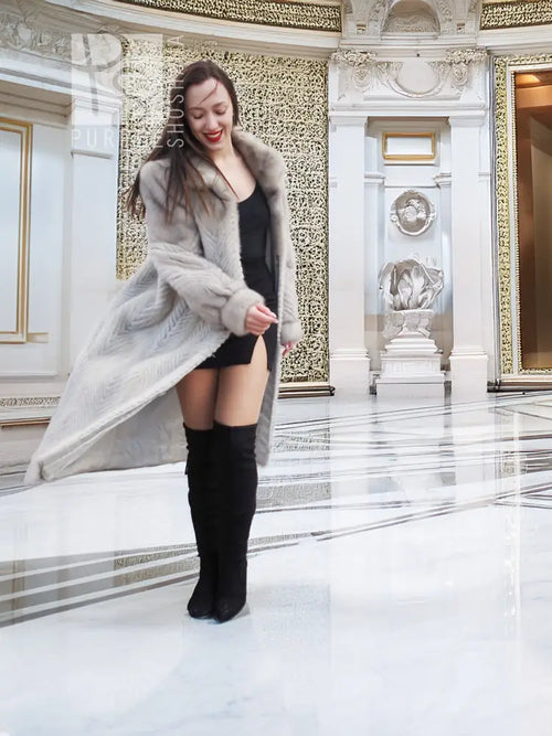 Light gray long mink-style coat with hood and deep cuffs over black dress.