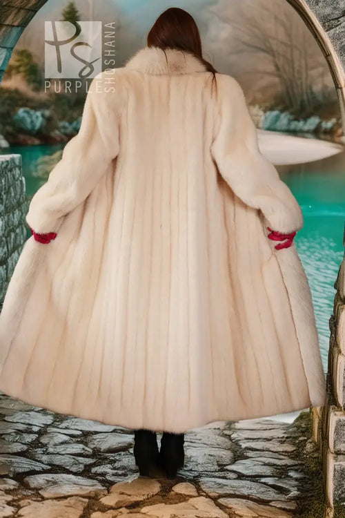 Back view of a white fur coat with red cuff details and a flowing, full skirt