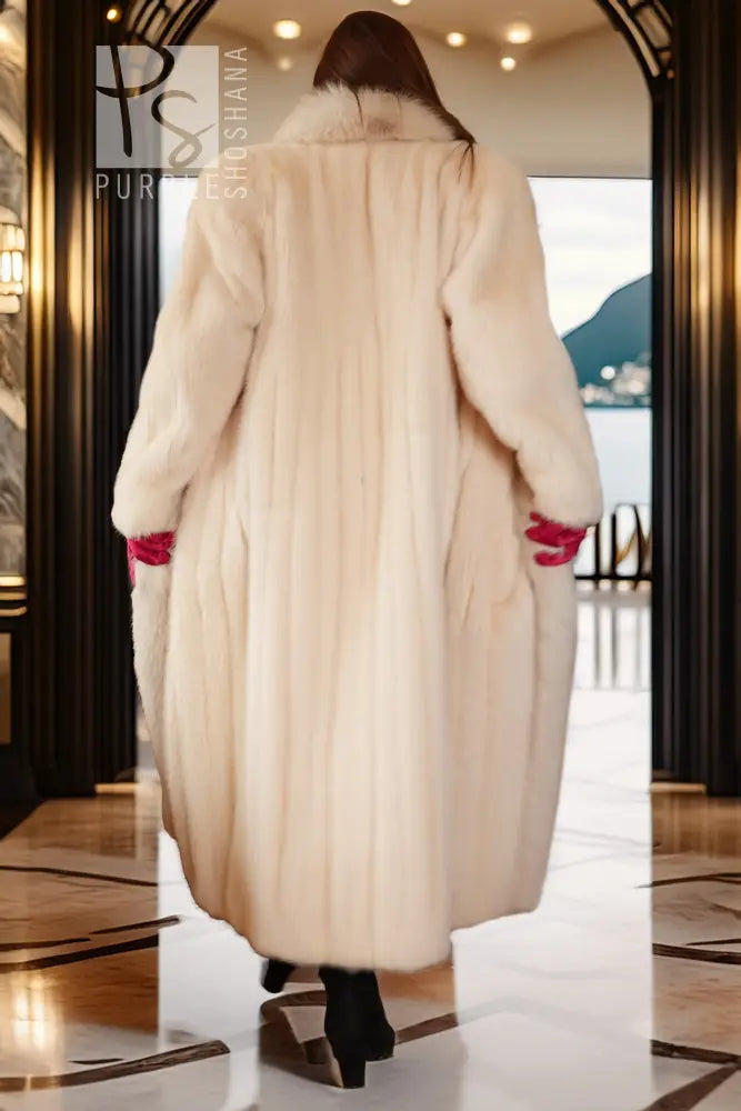 Back view of white mink fur coat with fox trim, long length and red cuff accents