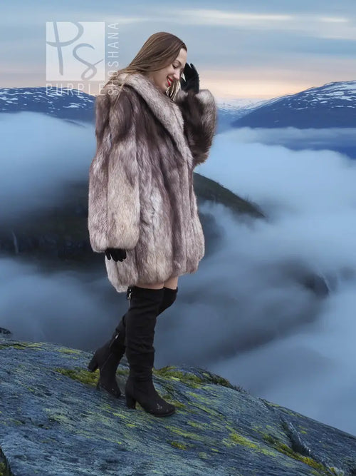 Light gray plush fur coat with shawl collar, long sleeves, worn over dark pants