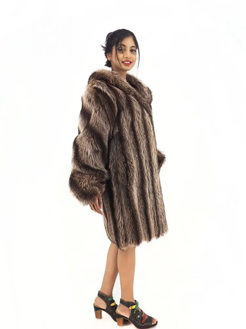 Raccoon fur coat with hood, back-leaning side view showing wide sleeves