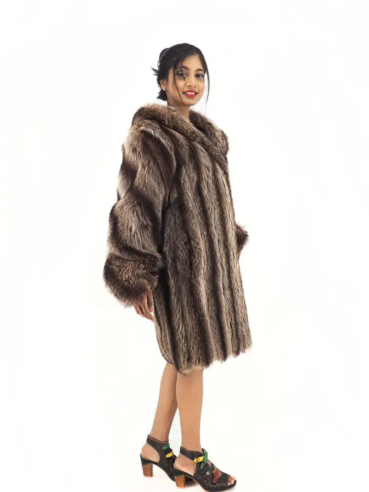 Raccoon fur coat with hood, back-leaning side view showing wide sleeves