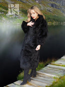 Black plush fur long coat with front opening and wide cuffs, standing by lakeside steps.