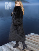 Black plush fur long coat with wide collar, three-quarter view standing on dock boards.