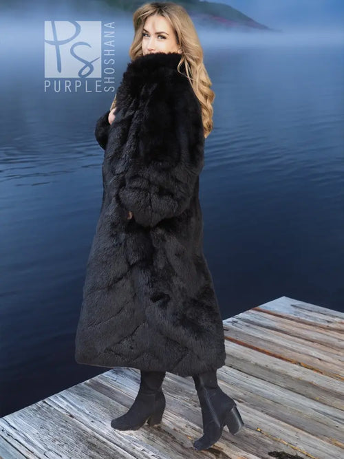 Black plush fur long coat with wide collar, three-quarter view standing on dock boards.
