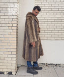 Side profile of long raccoon-fur coat with thick fur collar and button placket