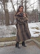 Raccoon fur coat with hooded fur collar and toggle closure, long A-line side view