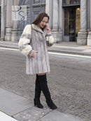 Light gray hooded mink fur coat with cream cuff accents and long sleeves