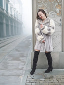 Mink fur coat with open front and striped cuffs, collar up and side view.