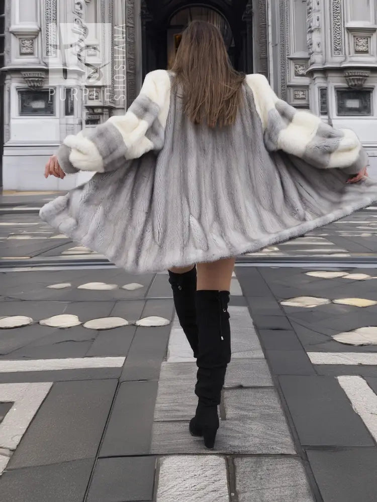 Back view of light gray mink fur coat with flared hem and cream cuff accents