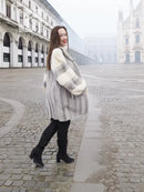 Side view of light gray mink fur coat with cream block sleeves and flared hem