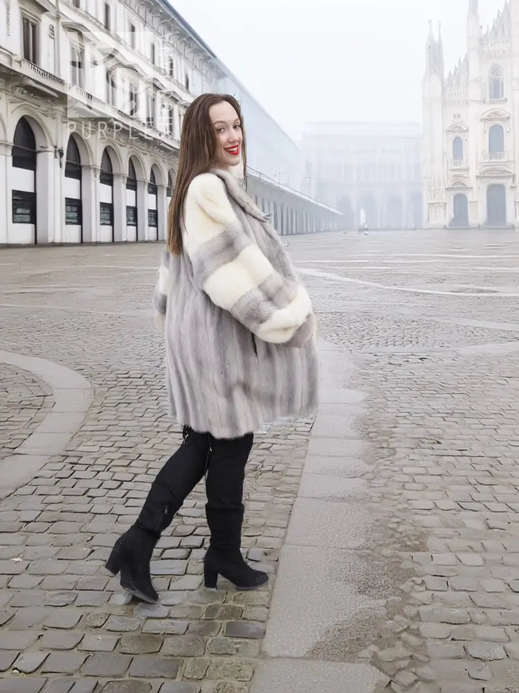 Side view of light gray mink fur coat with cream block sleeves and flared hem