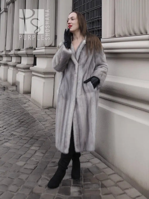 Grey mink fur coat with hood, visible side profile, and black cuff accents.