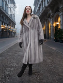 Grey mink fur coat with hooded collar, open front, and straight long silhouette.