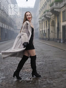 Light gray mink fur coat with hooded neckline and long, swingy hemline.
