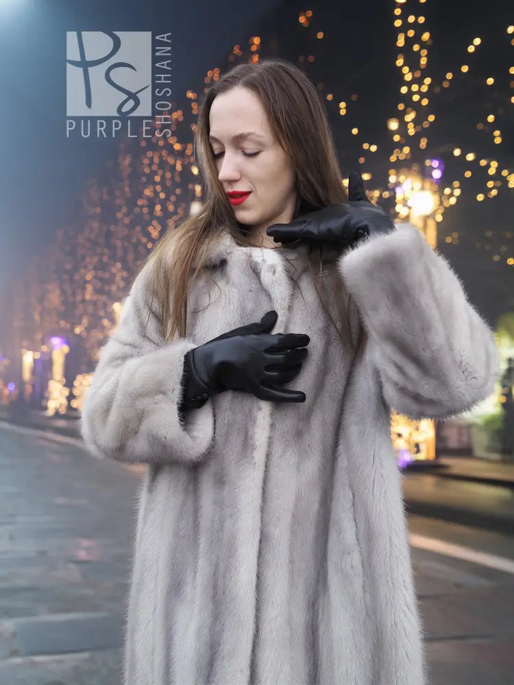 Grey mink fur coat with hood and front button closure, black gloves held up.