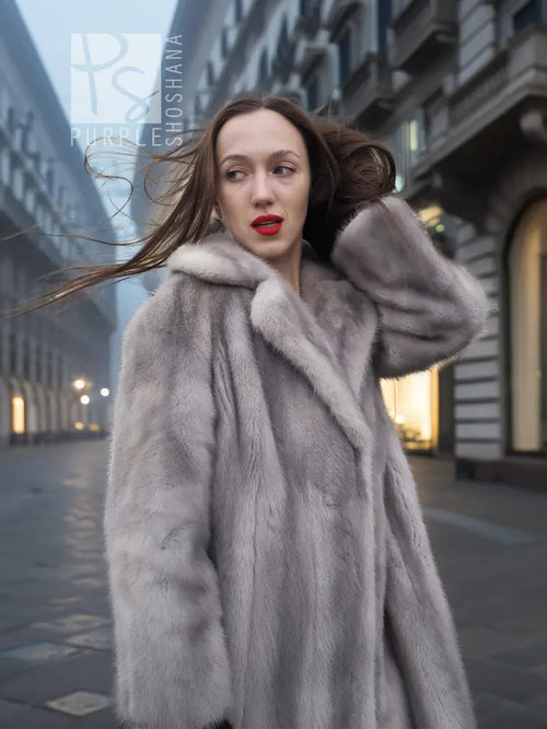 Light gray mink fur coat with hooded neckline and thick fur shoulders, open front.