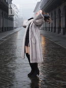 Light gray mink fur coat with hood, long sleeves, and open front with draped hem.