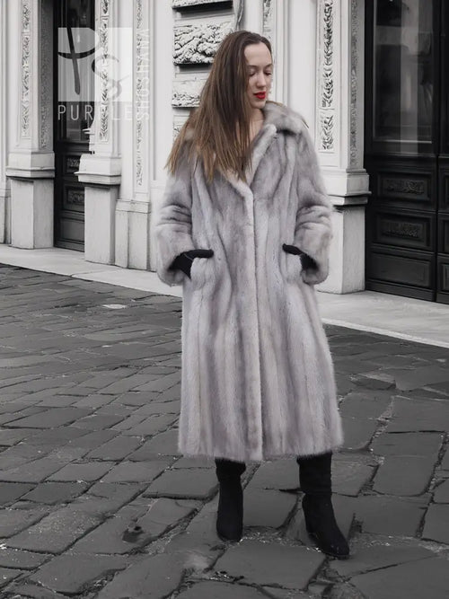 Grey mink fur coat with hood and long sleeves, black cuff accents.