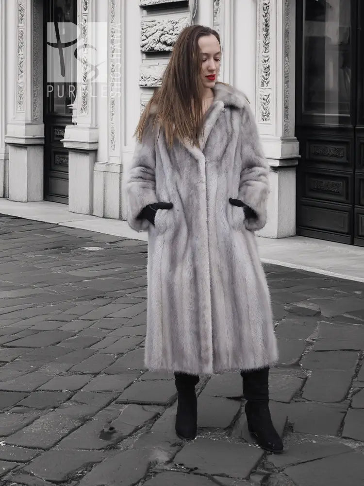 Grey mink fur coat with hood and long sleeves, black cuff accents.