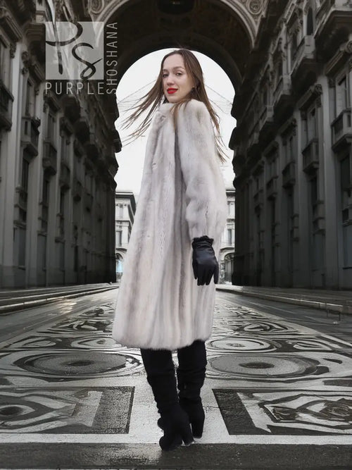 Light gray mink fur coat, long length with voluminous sleeves and black gloves.