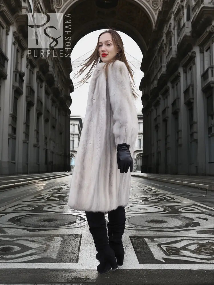 Light gray mink fur coat, long length with voluminous sleeves and black gloves.