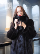 Black mink fur coat with fox fur collar, close-up holding the collar
