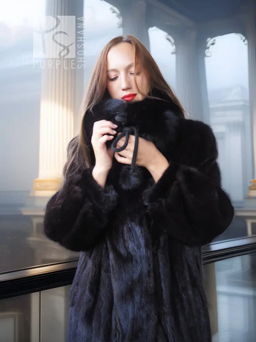 Black mink fur coat with fox fur collar, close-up holding the collar