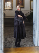 Black mink fur coat with fox fur collar, profile standing with hand on chest